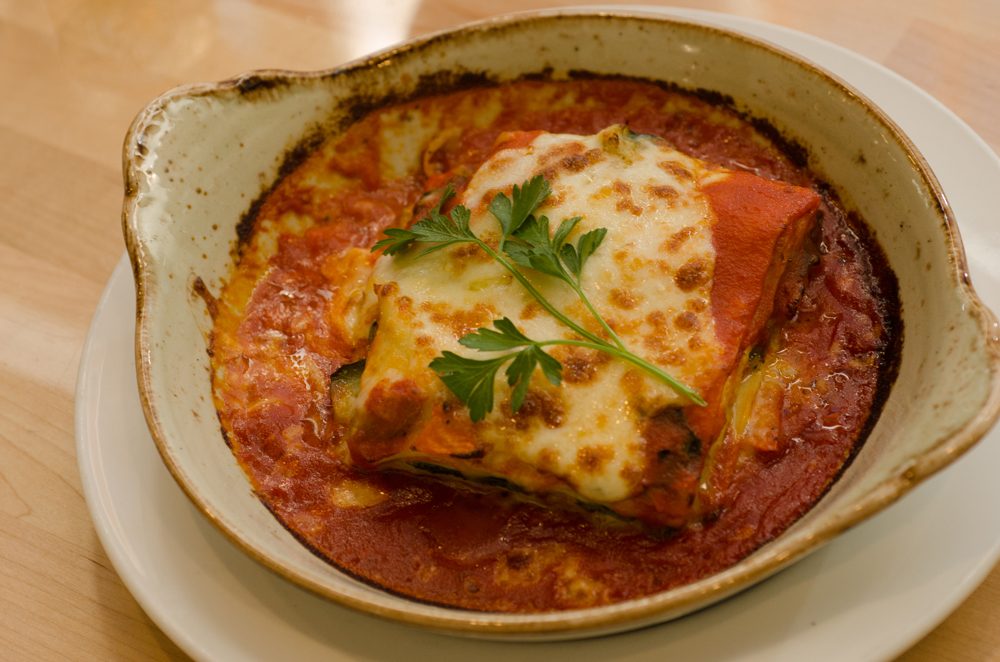 Lasagna Bolognese: Layered lasagna in béchamel, veal & beef ragu, marinara & parmesan cheese.